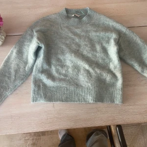 Ljusgrå stickad tröja XS - Supermjuk och fluffig ljusgrå stickad tröja från C i storlek XS. Tröjan har rund halsringning, ribbade muddar och en relaxed passform. Perfekt nu till hösten och till skolan!