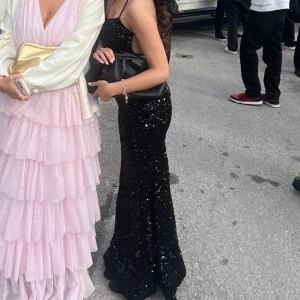 Svart glittrig balklänning  - Säljer nu min superfina balklänning. Klänningen är svart med paljetter och med knytning i ryggen. Den är i storlek 34/XS men passar mig som också kan ha 36/S. Den är tajt upptill men väldigt bekväm och den går ner till marken på mig💕