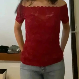 Röd offshoulder spetstopp - Säljer en snygg röd topp i spets med offshoulder-modell och korta ärmar. Toppen har en romantisk vibe med vågig kant upptill och är figurnära. Perfekt för dig som vill sticka ut med en feminin och trendig look. Är i storlek M men passar mig fint som brukar ha XS/S 💗💗