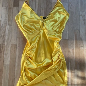 Gul klänning - En söt thriftad minidress. Superskön, superkort och endast använd två gånger ute av mig. Stretchig i tyget. Lite släppt i en yttre söm på baksidan (se bild 4,) därav priset. Skriv  för fler bilder! Läs gärna bion innan köp.