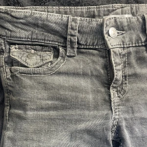 Grå bootcut jeans med fickdetaljer - Snygga grå jeans med bootcut passform och coola fickor med knapp både fram och bak. Har använt ungefär 3 gånger. Dem är i storlek 158 (barnstorlek) men jag har egentligen S och de funkar ändå på mig. (Jag är 163 cm lång) dem är i nytt skick har använt dessa ca 3 gånger. Men har inte prislapp