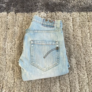 Ljusblå dondup jeans  - Säljer ett par blåa dondup jeans. Ny pris är ca 3500kr. Mitt pris 999kr. Priset är ej hugget i sten. Hör av dig vid funderingar!