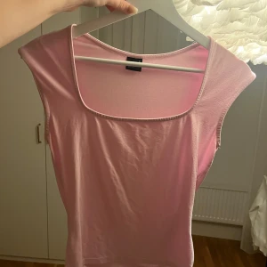 Ljusrosa ärmlös topp Gina Tricot - Supersöt ljusrosa ärmlös topp från Gina Tricot med fyrkantig ringning. Enkel och stilren design i mjuk bomull, perfekt att matcha med jeans eller kjol. Snygg passform som känns både trendig och bekväm. Sparsamt använd och normal i storleken. Hör gärna av er vid frågor eller funderingar! 💕