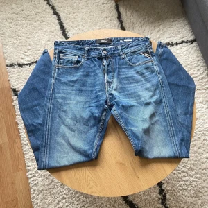 Blåa Replay - Hej👋 Säljer ett par snygga blå jeans från Replay i klassisk femficksmodell. Jeansen har raka ben, normal passform och coola slitningar framtill🙌 Materialet är robust denim med tydliga kontrastsömmar och Replay-logga på bakfickan. Perfekt för dig som gillar en tidlös streetstil💯  Byxorna är i Grover modell och har storlek W31 L32!📐  Vid frågor: Meddela oss📩