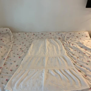 Vit långkjol från H&M - Säljer en vit långkjol från H&M i storlek M. Kjolen har en luftig och flowy känsla med bred resår i midjan och sydda volanger i flera lager. Går ända ner till fötterna på mig som är 170cm. Har bara använts en gång!