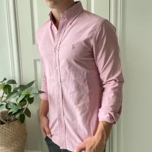 Ralph Lauren skjorta Rosa S slim fit  - Ralph Lauren skjorta Rosa S slim fit , defekter: liten fläck på ärmen men märks ju inte om man kavlar upp den, har ej försökt ta bort. Svett fläckar under armhålorna. Modellen är 180,75 kg. Kom med frågor 🫶