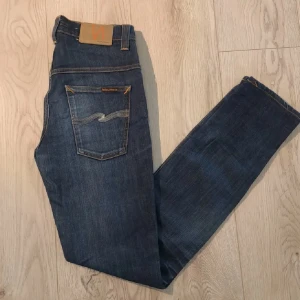 Nudie Jeans blå jeans W30 L34 - Säljer ett par klassiska blå jeans från Nudie Jeans i modellen W30 L34. Jeansen är defekt fria. Nypris 1699kr! Mitt pris 450 kr!