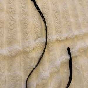 Svart bälte med silvriga stjärnor och annat  - Säljer ett smalt svart bälte med silveriga geometriska detaljer längs hela bandet. Bältet har en klassisk form och är perfekt för att ge en extra touch till din outfit. Passar till både jeans och kjol.