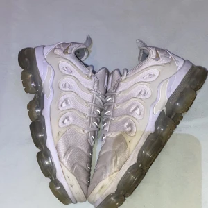 Nike Air Vapormax Plus vita sneakers - Nike Air Vapormax Plus sneakers i vitt med genomskinlig bubblig sula. Använda ganska mycket men ändå fina och snygga. Priset går att diskutera.