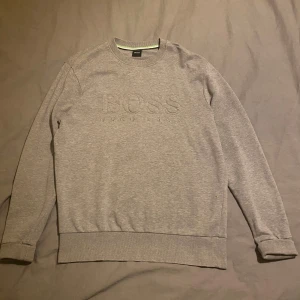 Grå sweatshirt från Hugo Boss - Väldigt varm och skön säljer för jag inte använder den. Inga hål eller sånt. Snabb frakt samma dag eller dagen efter. Enkel att matcha med. 