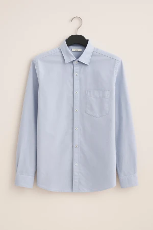Ljusblå skjorta med knappar - Snygg ljusblå skjorta med klassisk krage och bröstficka. Skjortan har långa ärmar och knappar hela vägen framtill. Perfekt för dig som gillar stilrena och enkla plagg. Materialet är mjuk bomull som känns skönt mot huden.