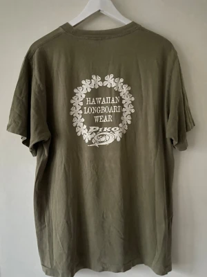Piko Hawaiian Longboard Wear T-shirt - Piko Hawaiian Longboard Wear T-shirt i fint skick. Skriv om fler bilder eller mått önskas.