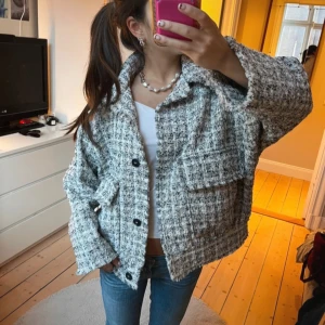Gråvit rutig kappa från H&M - Säljer en oversized gråvit rutig kappa från H&M. Jackan har stora fickor framtill och är jätte söt! I bra skick och gör outfiten lite roligare