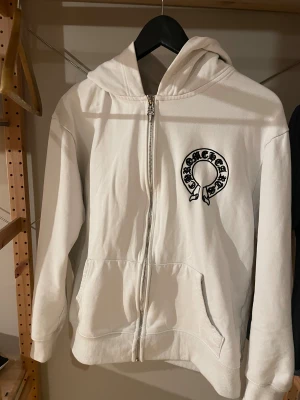 Chrome hearts hoodie - En hoodie från chrome hearts. Den klassiska logan på fram och baksidan med en detaljerad dragkedja👍. Den har en liten blå fläck på vänstra armen men den syns knappast.(Du vet varför den är billig)
