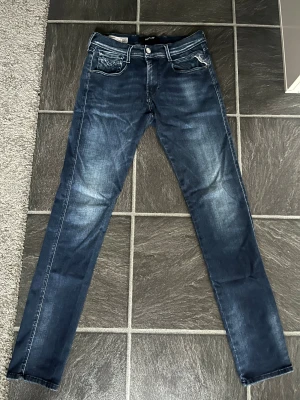Replay Anbass jeans blå - Säljer ett par Replay Hyperflex Anbass jeans i mörkblå tvätt. Modellen har fem fickor, normal passform och klassisk jeanslook. Materialet är stretchigt för extra komfort och rörelsefrihet. Jag skulle säga att skicket är 8/10 för har inte använt dem så mycket.