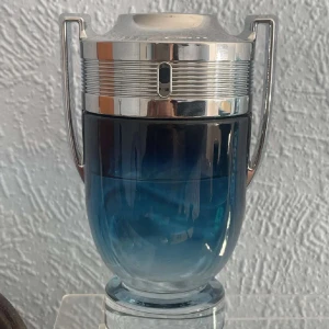 Paco Rabanne Invictus Parfum - En ikonisk parfym från Paco Rabanne med en cool, blå design. Perfekt för dig som vill sticka ut och ge ett självsäkert intryck. Flaskan har en unik troféform som gör den till ett snyggt inslag i badrumshyllan. 45/50 ml kvar av 100 ml