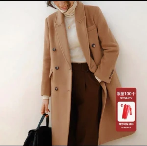 Beige kappa med knappar och fickor - Snygg beige kappa  med dubbelknäppning och klassisk krage. Jackan har fyra dekorativa knappar vid ärmslut, två framfickor och en bröstficka. Materialet är mjukt och känns lyxigt, perfekt för dig som gillar stilrena och tidlösa plagg.