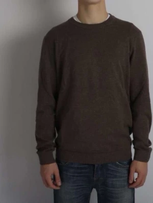 Brun kashmir stickad tröja med rund hals - Säljer en enkel och stilren brun stickad tröja med rund hals. Tröjan har långärmade och ribbade muddar vid ärmslut och nederkant. Perfekt att matcha med jeans för en avslappnad look.