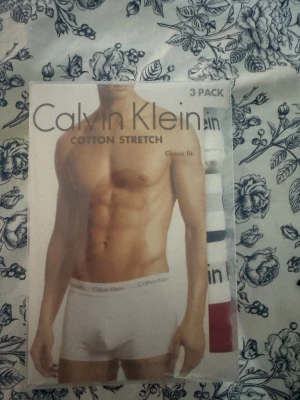 Calvin Klein vit/röd/blå bomullskallingar S - Säljer helt nya kalsonger från Calvin Klein i storlek S, tillverkad i mjuk bomull med stretch. Kallingarna kommer i ett pack av 3 där det finns färgerna vit, rött och marinblått, har klassisk passform och logotyp på kanten. Perfekt för dig som gillar enkel och snygg design. Kvar i orginalförpackning, oöppnad!