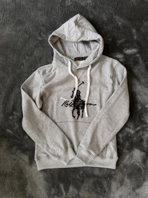 Ralph lauren hoodie - Grå Ralph Lauren hoodie med vita snören, skön och tjock i unik modell som man inte ser ofta