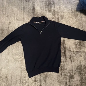 Sand copenhagen halvzip - Säljer en mycket stilren halv zip tröja från sand copenhagen gjord på 100% merinoull i en mycket fin mörkblå färg. Köpte tröjan i somras och är i mycket bra skick. Tröjan tvättades dock i för hög värme och krympte, skulle säga att den är xs nu.                                                                                Nypris ligger på ca 1,500kr