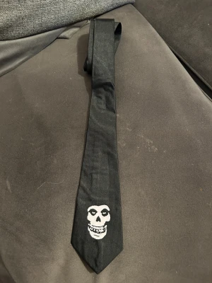 Slips med Misfits - Helt ny slips med Misfits. Bredd på den bredaste delen längs ner 7,5 cm,