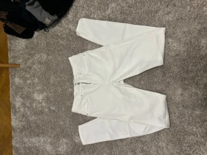 Vita jeansbyxor från ONLY, storlek M - Säljer ett par fräscha vita jeansbyxor från ONLY i storlek M/32. Byxorna har klassisk femficksdesign, raka ben och normal passform. Perfekta till en clean och stilren look. Materialet är mjukt och stretchigt för extra komfort.