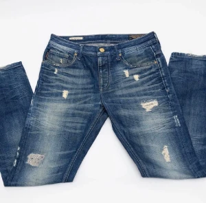 Jack & Jones  - Blåa jeans från Jack & Jones| snygga slitningar och detaljer| ljus tvätt| normal passform| 30/32