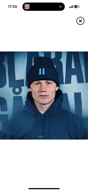 Mörkblå Djurgården mössa med blå ränder - Snygg svart ribbstickad mössa från Djurgården med två ljusblå vertikala ränder framtill. Perfekt för dig som vill visa klubbkänsla och hålla dig varm på matchen. Klassisk form och mjukt material som sitter skönt på huvudet.