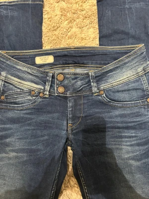 Lågmidjade utsvängda jeans - Midjemått tvärsöver: 37cm Innerbenslängd: 79cm Längd längst ner vid benet: 23cm