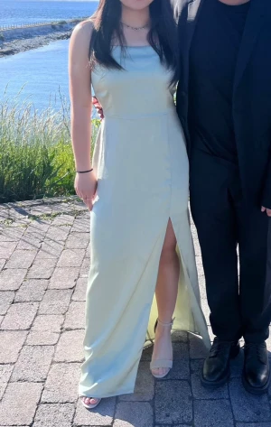 Grön satinklänning - Superfin satinklänning med slits från NAKD Använd en gång, jättebra skick Inga anmärkningar  Perfekt till bal eller andra festligheter