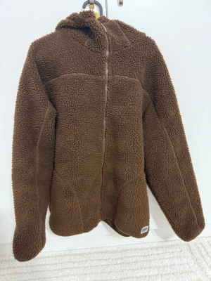 Brun teddyjacka - Mysig brun teddyjacka från Zara med huva och dragkedja framtill.  Storlek S-M