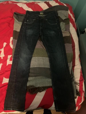 Lee Jeans - Supersnygga Lee Jeans med mörkblå färg. Har blivit för små för mig men var riktigt sköna så länge som jag kunde ha dom! Inte helt säker på W-storlek men står 12 Y inuti byxorna så skulle gissa på ungefär W 28. Har små små jack i benen men syns nästan inte ens. Pris kan diskuteras. Byxorna har knappt avndvänts. Max tre fyra gånger