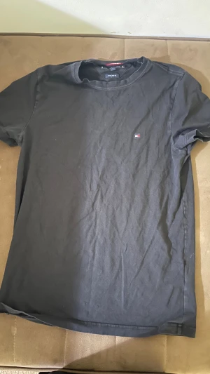 Svart Tommy Hilfiger t-shirt slim fit - Svart t-shirt från Tommy Hilfiger i extra slim fit-modell. Klassisk rund hals och korta ärmar. Liten broderad logga på bröstet ger en clean och stilren look. Tillverkad i mjuk bomull som känns skön mot huden.