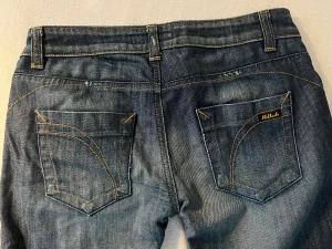 Mörkblå jeans från Killah - Snygga mörkblå jeans från Killah med raka ben och klassiska kontrastsömmar. Jeansen har broderad logga på fickan och knapp med märkets namn. Tillverkade i jeansmaterial med en cool tvättad look och femficksdesign. Storlek xs-S. Priset kan diskuteras 