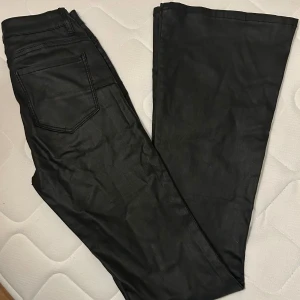 Skinnbyxor (ej äkta skinn) st XS - Snygga utsvängda byxor i skinnimitation från Monday. Superfint skick bara använda ett par gånger. St XS.