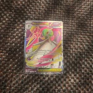 Mega Gardevoir EX - Mega Gardevoir EX är ett holografiskt samlarkort från Pokémon-serien, perfekt för dig som älskar coola och färgglada kort! Med unika attacker som Overflowing Wishes och Mega Symphonia är detta ett måste för alla unga Pokémon-tränare och samlare.