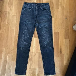 Zara man jeans  - Säljer ett par  svarta jeans från Zara Man Original Vintage med snygga slitningar och distressed detaljer framtill. Modellen har klassisk femficksdesign, raka ben och normal passform. Jeansen är tillverkade i jeansmaterial och har en cool vintage-look.