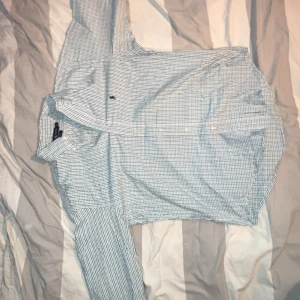 Rutig skjorta från Ralph Lauren - Snygg rutig skjorta från Ralph Lauren i vitt, grönt och grått. Modellen heter Blaire och är gjord i 100% bomull. Skjortan har klassisk krage, långa ärmar och knappar framtill. Perfekt för dig som gillar stilrena och tidlösa plagg med en preppy vibe.