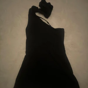 oneshoulder topp - ❗️ANVÄND INTE ”köp nu”!❗️Säljer en svart oneshoulder topp från Nelly i storlek S. Bandet i mitten knyter man i halsen. 💗Verkligen superfin men säljer då den var för stor och inte hann lämna tillbaka. Därav med helt ny med lappen kvar, endast testad en gång 🥰