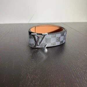 Bälte  - Helt nytt svart rutigt bälte med silvrig logga 