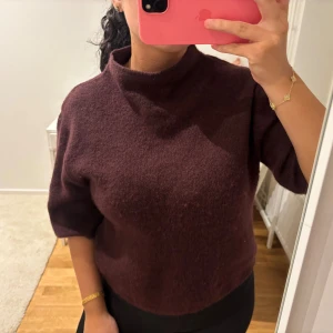 Vinröd polotröja från Gina Tricot - Mysig vinröd polotröja från Gina Tricot med halv hög krage och trekvartsärm. Tröjan är stickad och består av akryl, polyester, ull, alpacka och elastan vilket gör den både mjuk och varm. Perfekt för kyliga dagar och enkel att matcha med jeans eller kjol. Passar bra på mig som bär S