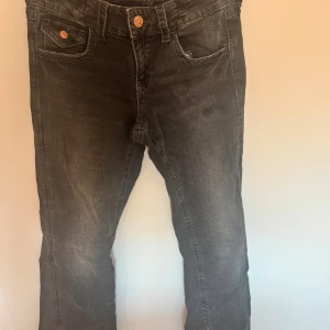 Svarta jeans med rosett från Gina Tricot - Snygga svarta jeans från Gina Tricot i storlek 164. Jeansen har klassisk femficksdesign, silverfärgade knappar och coola broderade rosetter på bakfickorna. Materialet är jeans med lätt tvättad look och raka ben. Passar mig som xs