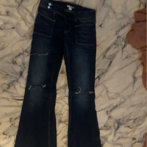 Mörkblå bootcut jeans med slitningar - Snygga mörkblå jeans med bootcut passform och slitna detaljer vid knäna. Super bra skick då dom knappt är använda. Storlek 164 men passar mig som vanligt vis har 34/36 i jeans❤️