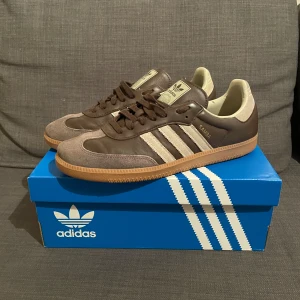 Adidas Samba OG bruna sneakers - Adidas Samba OG sneakers i brunt och beige med klassiska tre ränder på sidan. Ovandel i skinn och mocka, gummisula med mönster för extra grepp. Låg profil och snörning framtill. Skriv vid frågor och funderingar!!🤩
