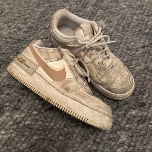 Nike Air Force 1 i beige och vitt - Säljer ett par Nike Air Force storlek 40 som är inte trasiga dom är bara smutsiga den är nog o ta bort så säljer dom för långt pris