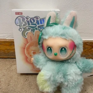 Pop Mart Biggie Dream Serenity Plush - Söt samlarfigur från Pop Mart Biggie Dream-serien, modellen Serenity. Mjuk plysch med pastellfärger och originalförpackning. Perfekt skick, inga synliga defekter. Passar samlare och som dekoration. Begränsad upplaga.