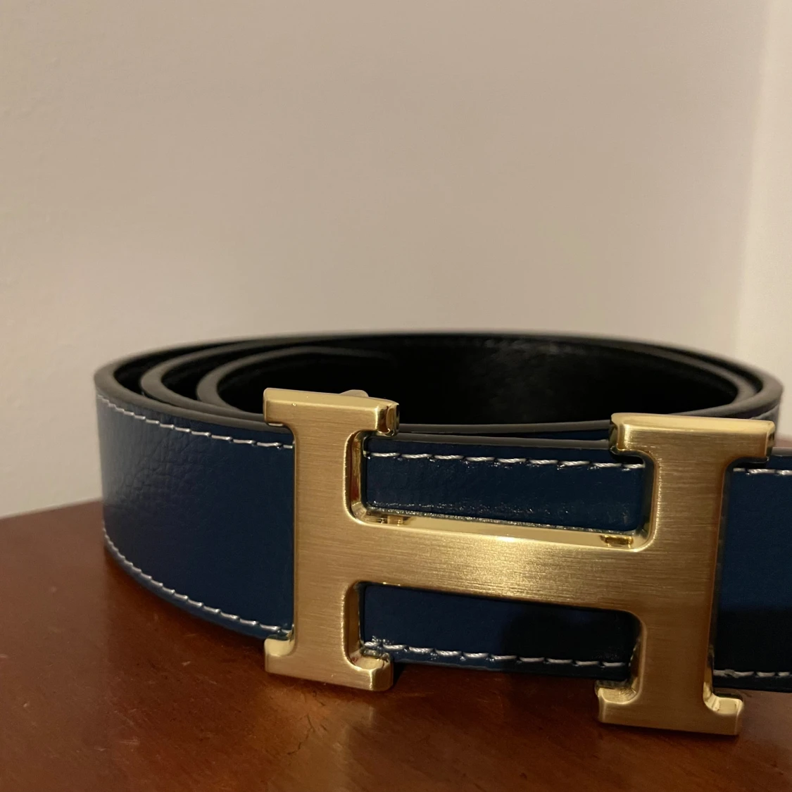 Bälte med H logo guld. Svart och blå