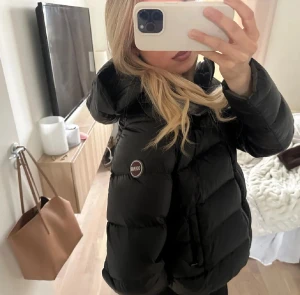 Svart pufferjacka från Colmar - !lånad bild! Säljer en svart pufferjacka från Colmar. Jackan har en hög krage och långa ärmar. Perfekt för kalla dagar med sin tjocka vaddering och stilrena look.