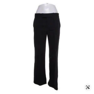 Svarta kostymbyxor med låg midja - Stilrena svarta kostymbyxor med låg midja och klassiska pressveck. Byxorna har hällor för bälte och diskreta bakfickor. Perfekta för en clean och dressad look. Byxorna är uppsydda/upplagda av tidigare ägare. Byxorna köptes secondhand och passade tyvärr inte mig, men hoppas de får ett bra hem hos någon annan 🥰